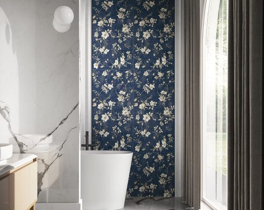 SIKO Výrazné kvetinové vzory na tmavomodrom podklade v kúpeľni s voľne stojacou vaňou.