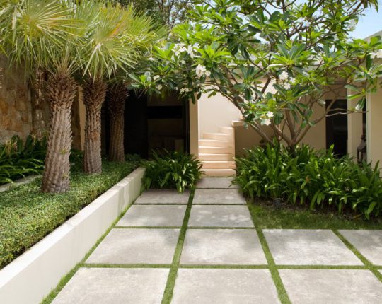 SIKO Venkovní dlažba čtvercového formátu v designu cementu položená v zahradě nebo na terase do trávníku.