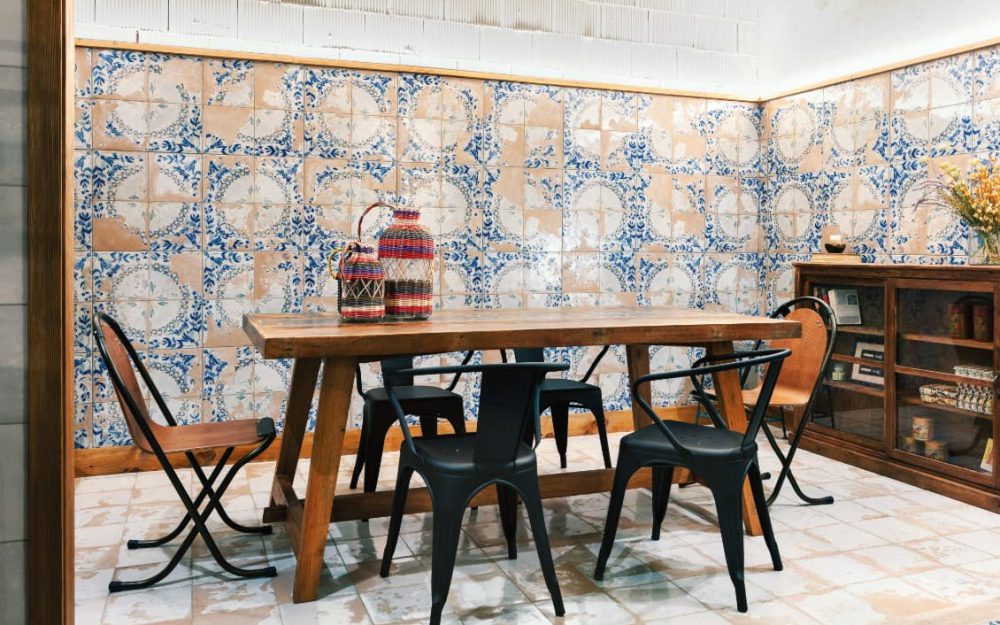 SIKO Vintage obklady s patinou v modrej farbe a dlažby v jedálni s masívnym stolom a stoličkami