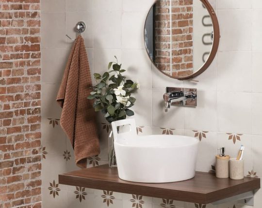 SIKO Nábytok na mieru, originálna doska pod umývadlo v tvare džberu v rustikálnej kúpeľni s obkladom v retro dizajne a odhalenými tehlami na stene.