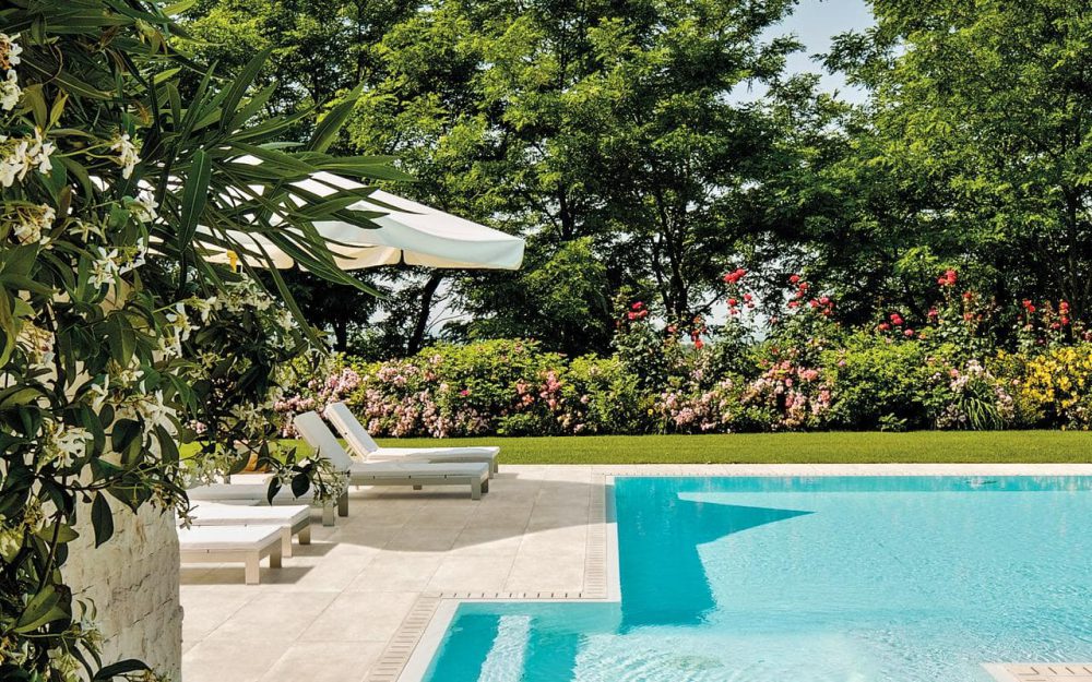 SIKO Velkoformátová obdélníková dlažba v designu světlého kamene vytvoří elegantní okolí bazénu na zahradě.