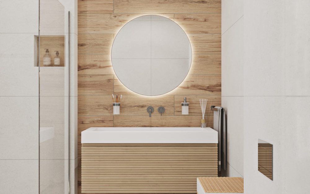 SIKO Moderní bílo dřevěná koupelna, závěsná umyvadlová skříňka ve světlém dřevěném dekoru, velké umyvadlo, dřevěný koš na prádlo, kulaté zrcadlo.