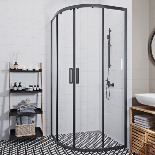 SIKO Sprchový kout bez vaničky čtvrtkruh s tmavými profily posuvných dveří, dřevěný regál s černými policemi a černobílá dlažba.