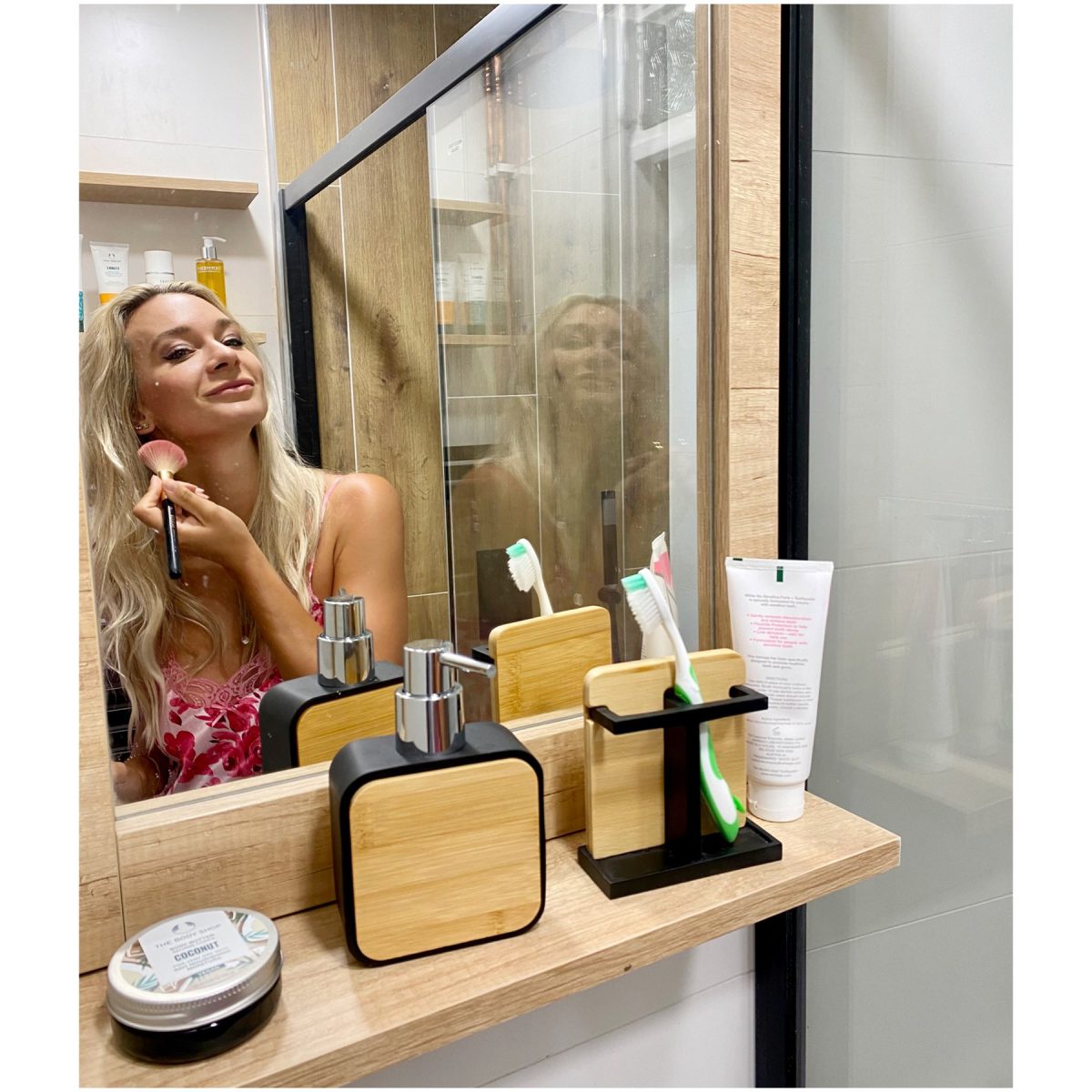 SIKO Zrkadlo v malej kúpeľni pre Báru Mottlovú ponúka poličku na odloženie kúpeľňových doplnkov v trendy kombinácii čierna a drevo.