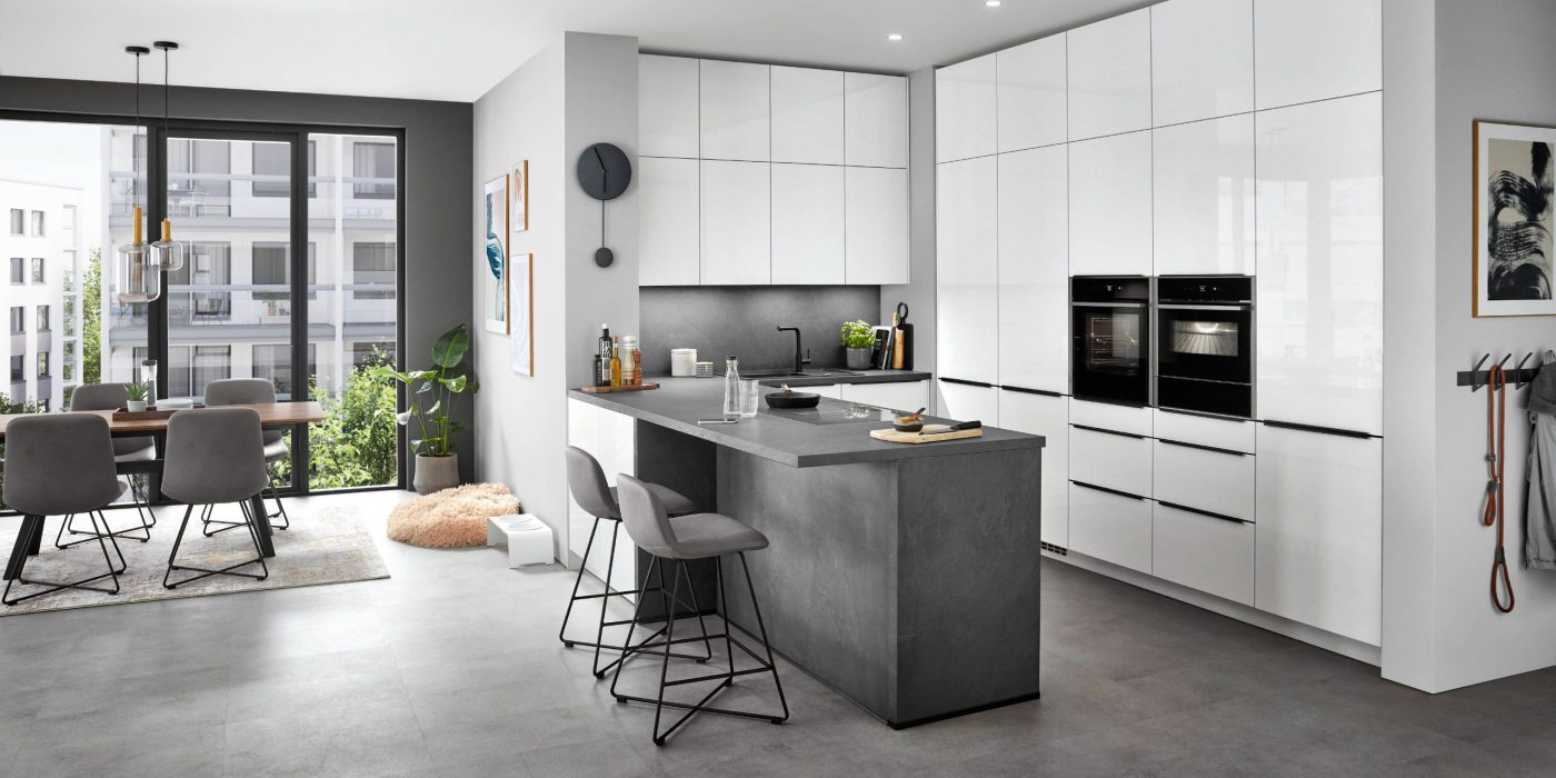 SIKO Moderná trendy biela kuchyňa s dvierkami až po strop v lesklom laku a kuchynským ostrovčekom v dizajne kameňa