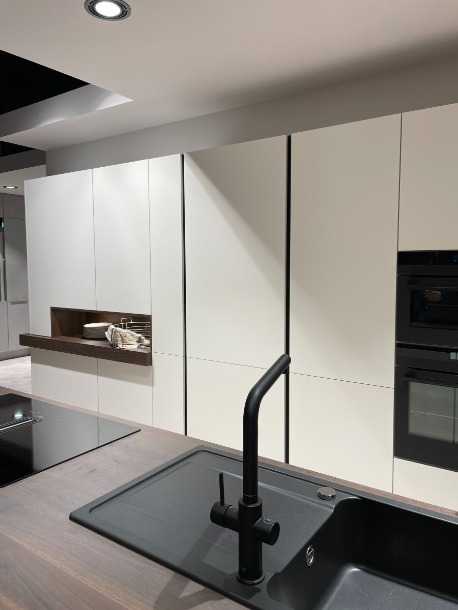 SIKO moderná bezúchytková biela matná kuchyňa s dvierkami až po strop, trendy čierny drez a čierna drezová batéria.