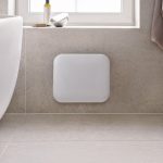 SIKO_Malý biely vykurovací panel pre príjemné teplo v kúpeľni. Obklad a dlažba v dizajne kameňa, voľne stojaca vaňa.