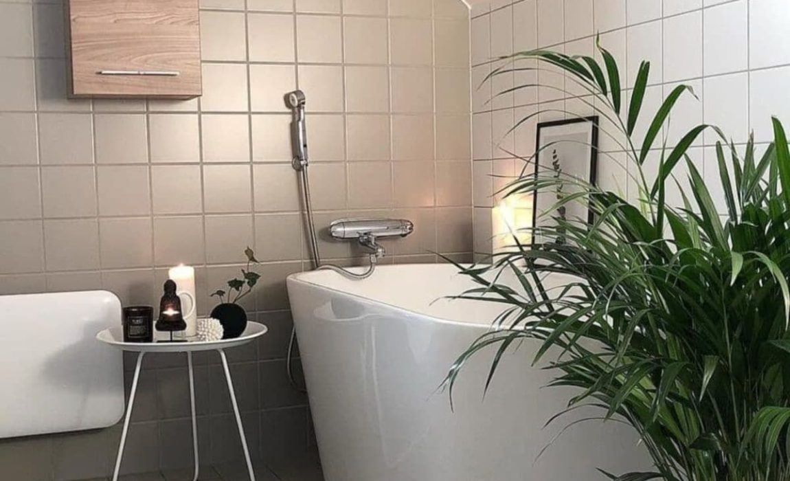 SIKO_Podkrovní koupelna vytápěná sálavým teplem z bílého topného panelu, volně stojící vana a čtvercové světlé obklady.