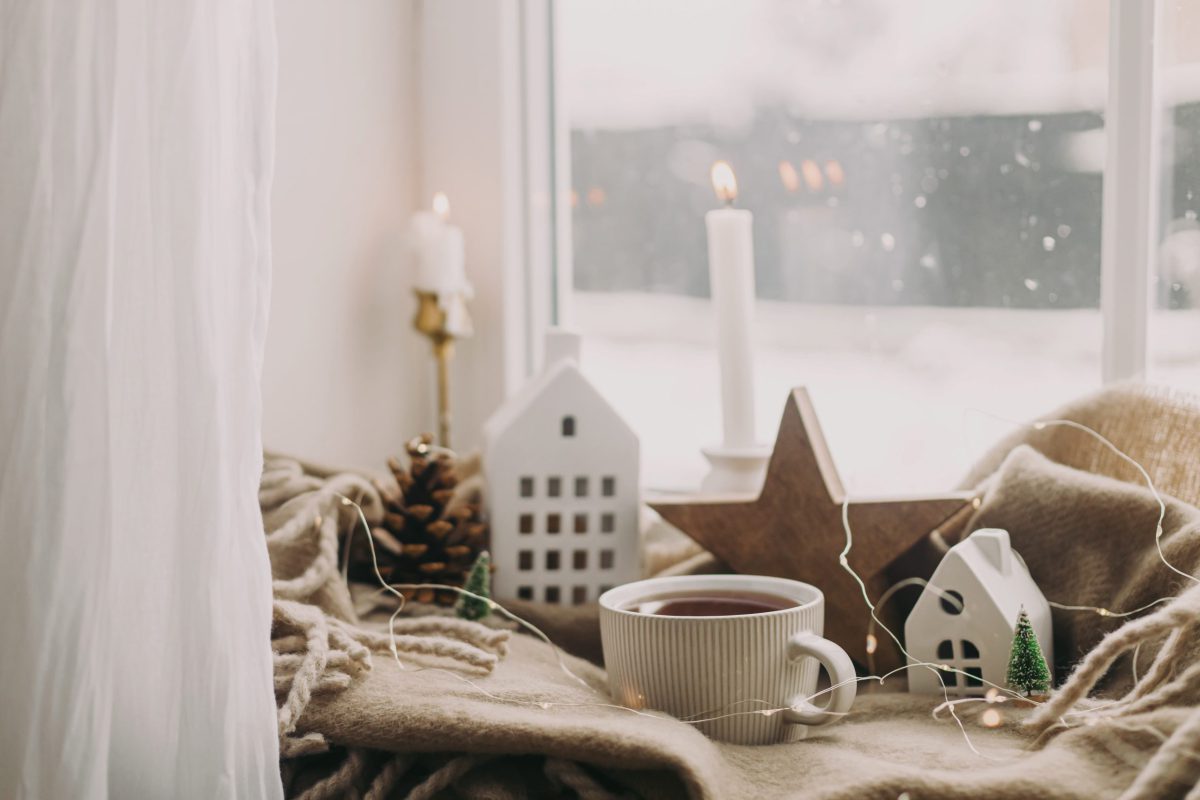 SIKO_Hygge, zimná atmosféra, dekorácie na okennom parapete, hviezdy, domy, šálka horúceho čaju.