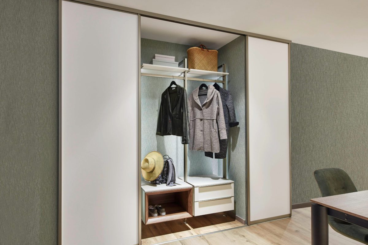 SIKO_Inspirace řešení šatny pomocí vestavné skříně s pousuvnými dveřmi, regálový systém pro zavěšení ramínek, botník a praktické zásuvky a regály.