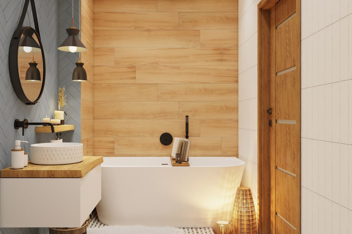 SIKO_Volně stojící bílá vana v útulné seversky laděné koupelně. Dřevěné a modré obklady na zdi, bílá dlažba, závěsná bíláskříňka pod umyvadlo s dřevěnou deskou