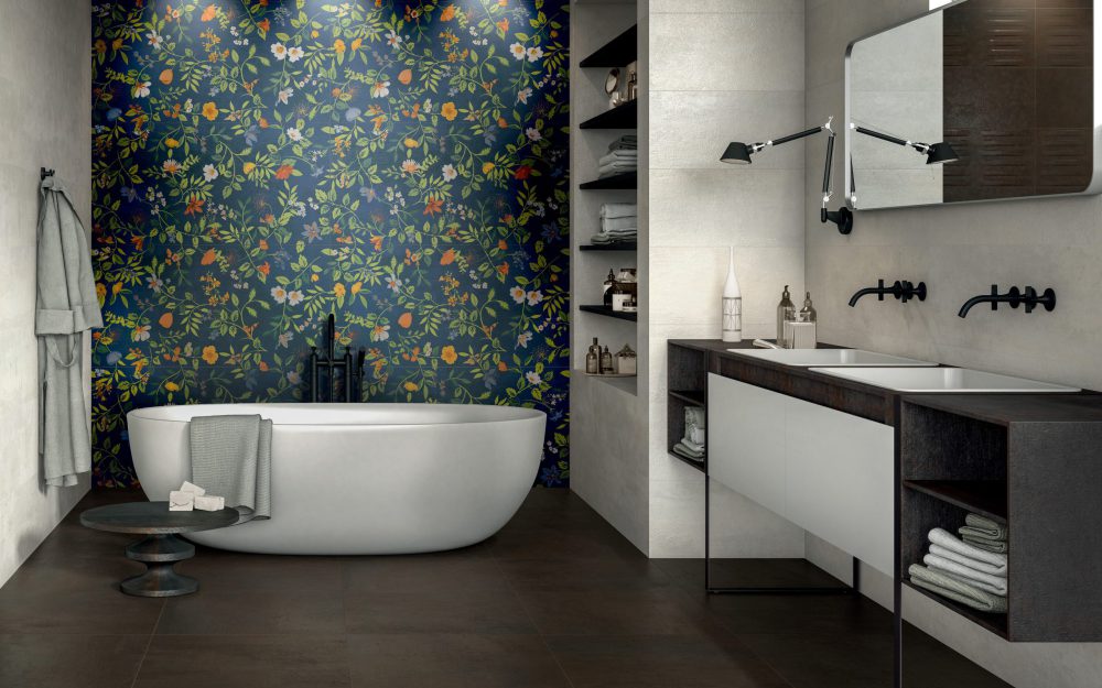 SIKO_Inspirace moderní koupelna, tmavě hnědá dlažba, obklad má výrazné květinové motivy na sytém modrém podkladu, volně stojící vana.