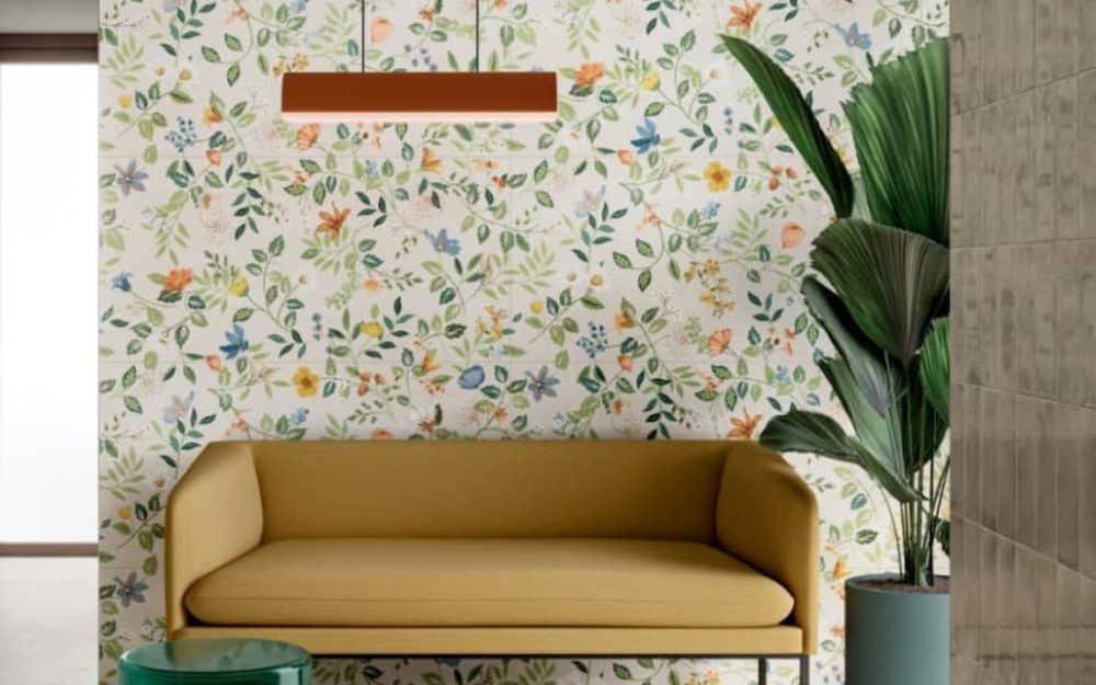 SIKO_Moderný farebný interiér s výraznými kvetinovými motívmi na bielom podklade, moderná horčicovo žltá pohovka v retro štýle, farebné doplnky