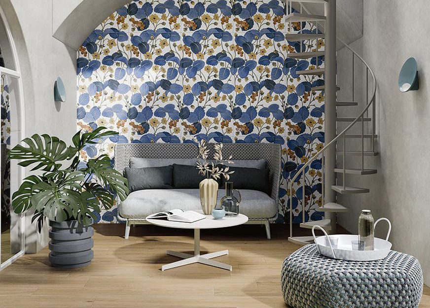SIKO_inšpirácia pre interiér s vysokým stropom, obklad s kvetinovým motívom, veľké modré listy, pohodlná sedacia súprava, drevená dlažba